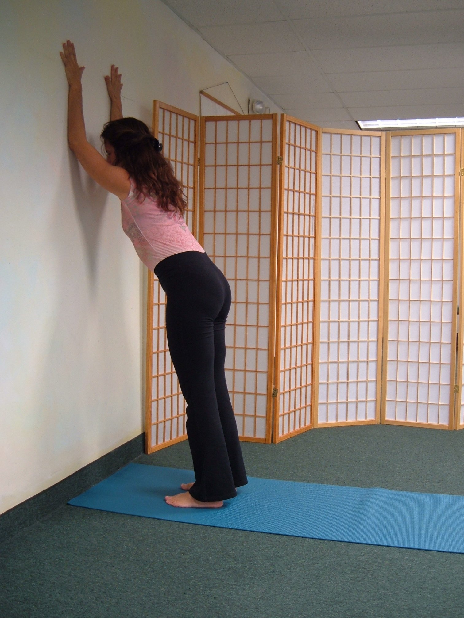 Practicing yoga at the wall helps support a yoga pose