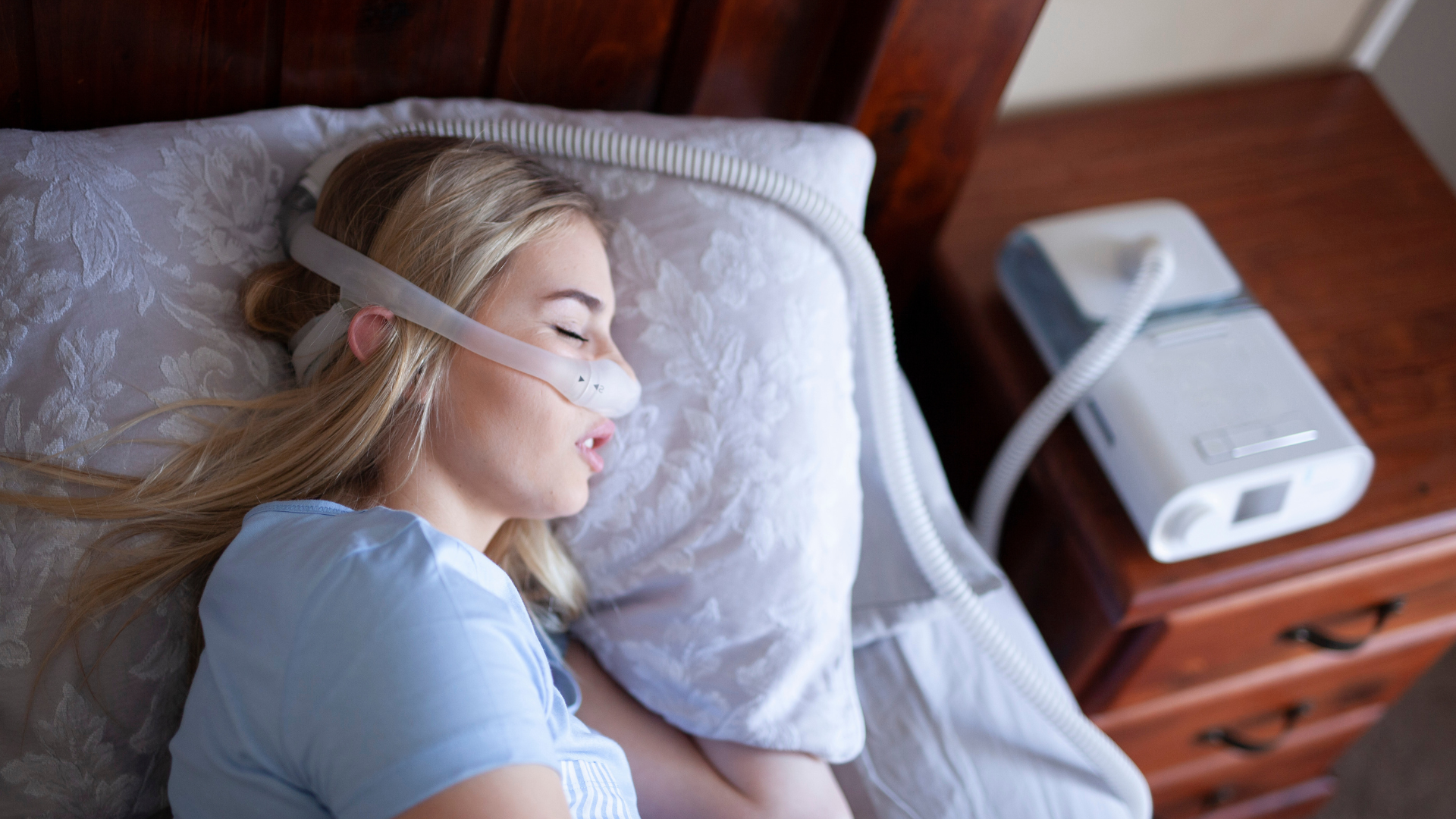 woman sleeping with CPAP machine to prevent sleep apnea which can cause heart problems in some people.