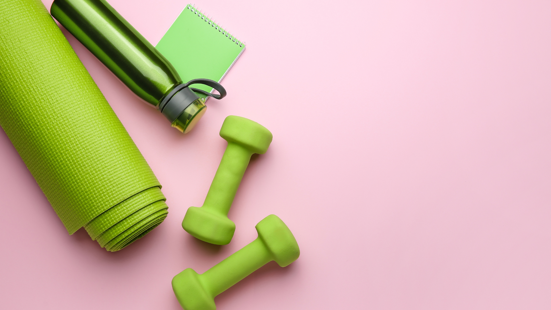 Dumbbells with notebook, yoga mat and bottle of water on color background.