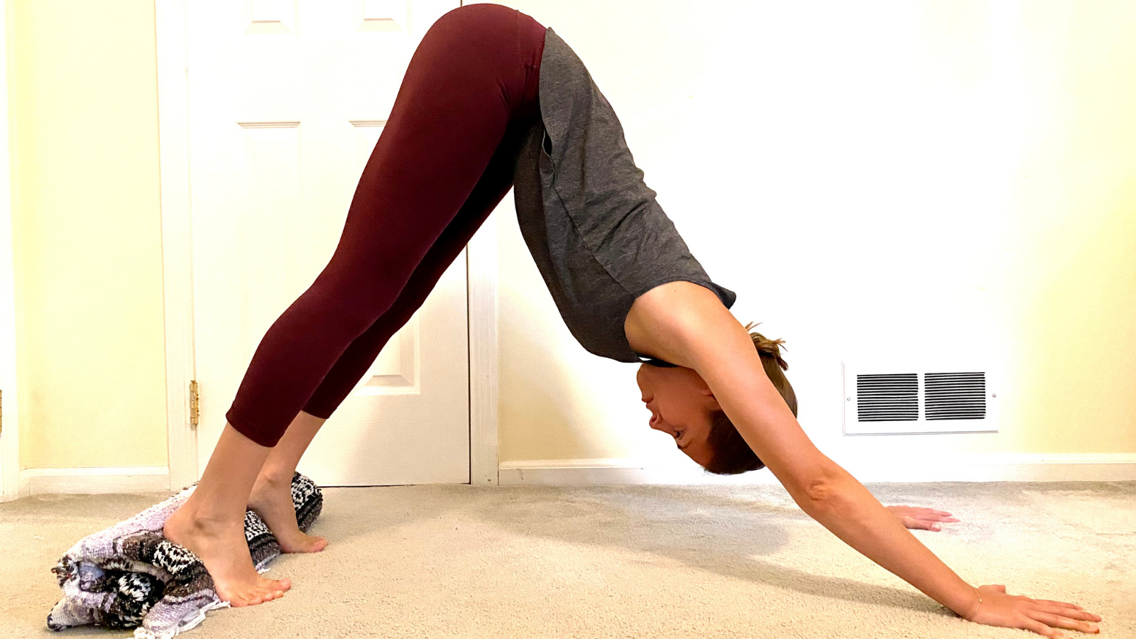 A comfortable version of Downward Facing Dog or Adho Mukha Svanasana placing a blanket under your heels to create greater comfort in the legs and feet