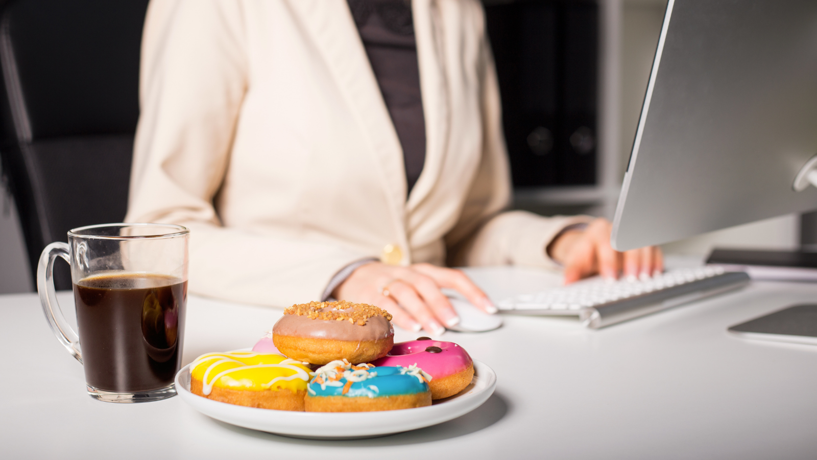 Woman having coffee and donuts at work.