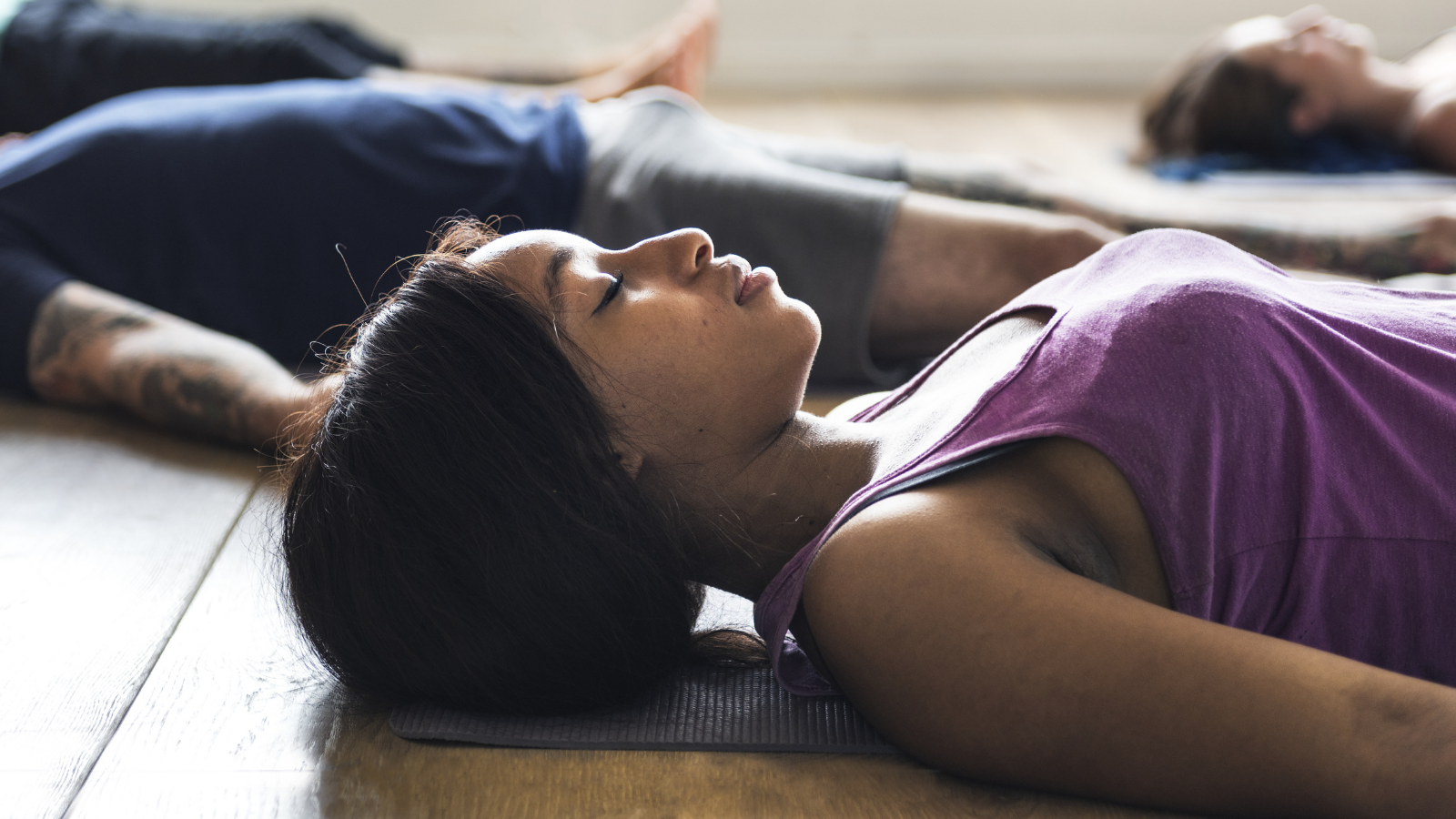 Group of diverse people are enjoying Savasana during a yoga class