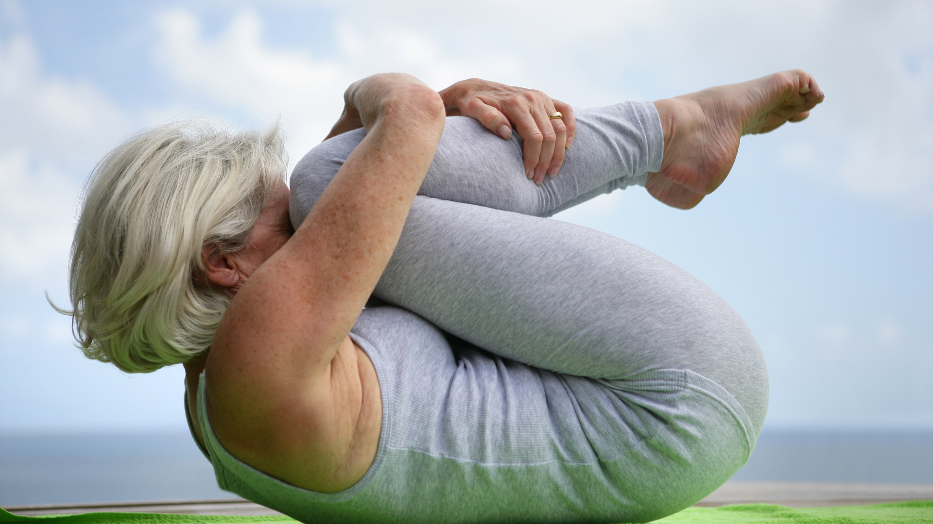 Woman holding a yoga position depicting how yoga has become a complementary therapy for alleviating pain and stress for individuals with breast cancer also reduction of inflammatory biomarkers