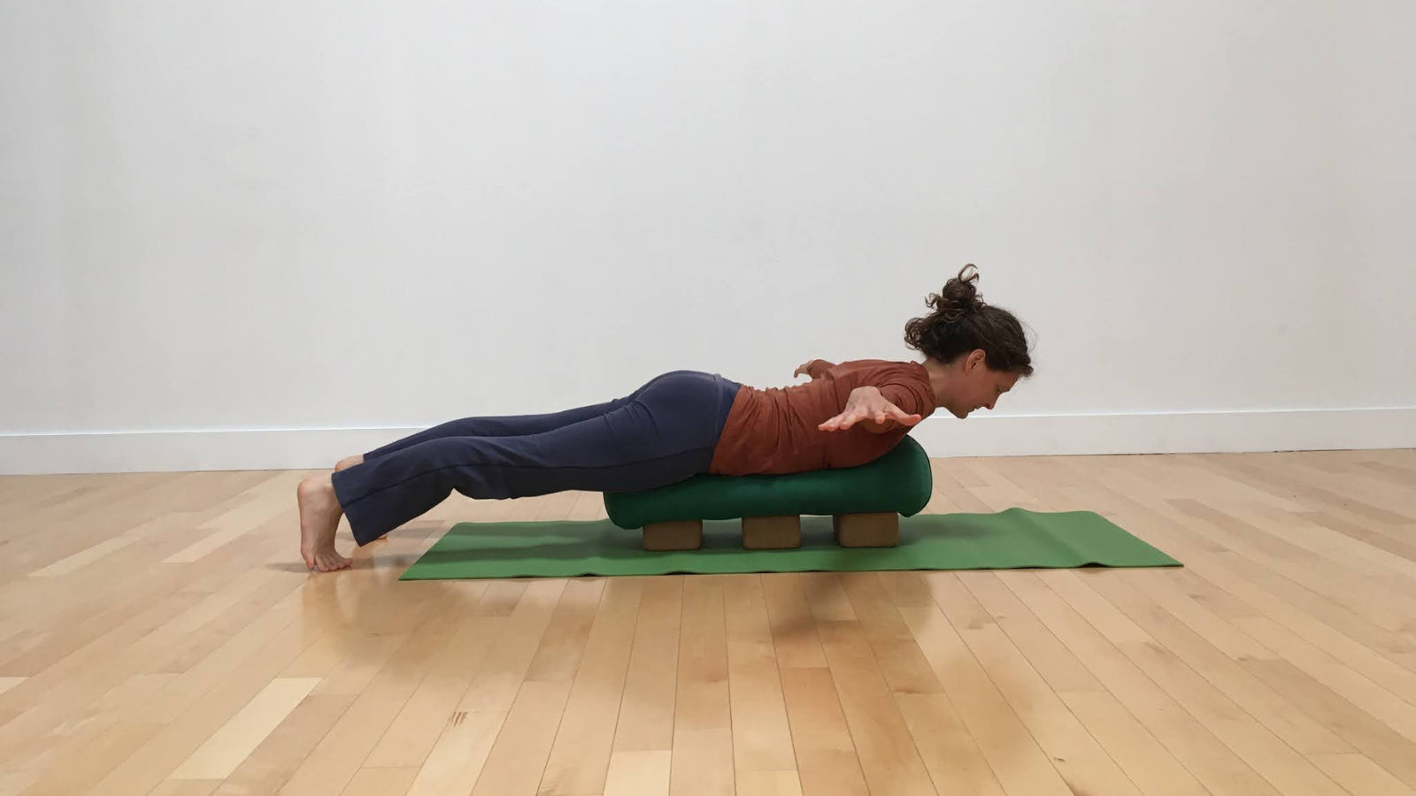 how to practice another version of arms to the side variation of locust pose or salabhasana with bolster and blocks