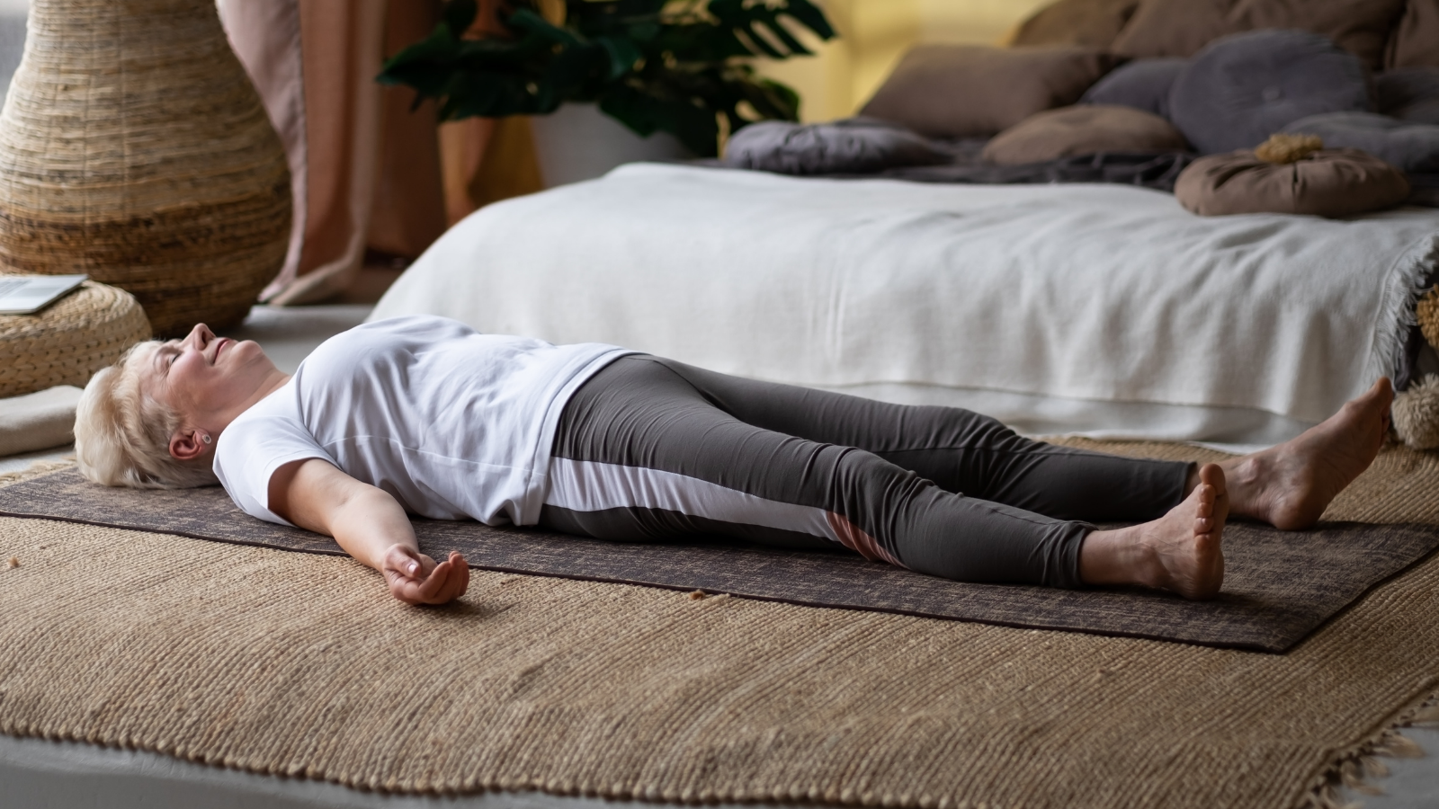 Senior woman lying on yoga mat after workout