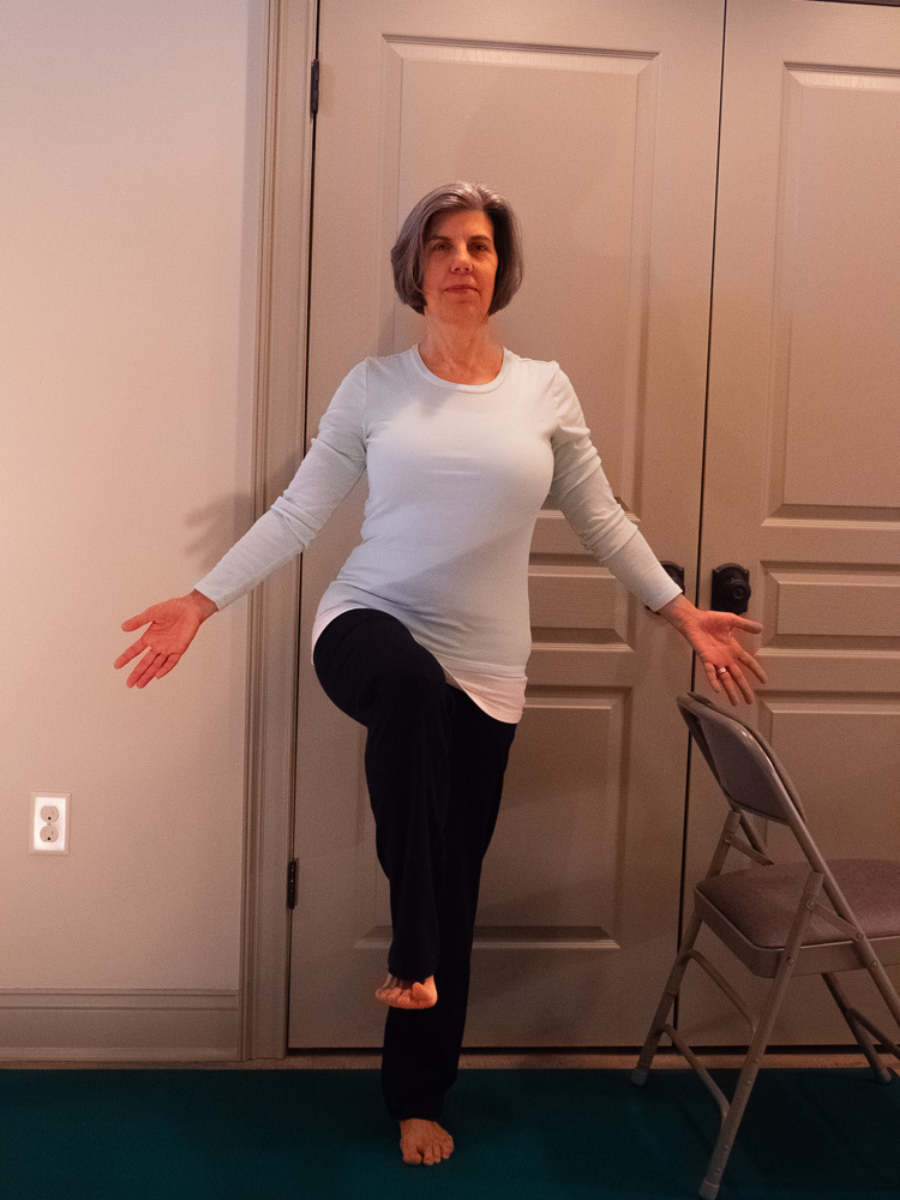 Knee to Chest Pose with hands spread wide is a challenging variation of this balance pose.